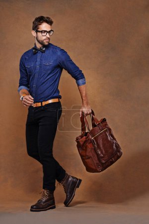 Photo for Travel, bag and man with fashion walking in studio, background and mockup for business vacation. Formal, style and model with luxury luggage for airport, journey to Italy and Italian leather shoes. - Royalty Free Image