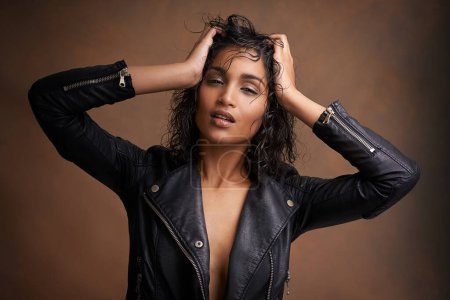 Photo for Woman, fashion and portrait in studio with leather jacket and beauty with makeup for bold, and chic. Indian person, model and edgy with curls and clothes for aesthetic and style for trend and cool. - Royalty Free Image