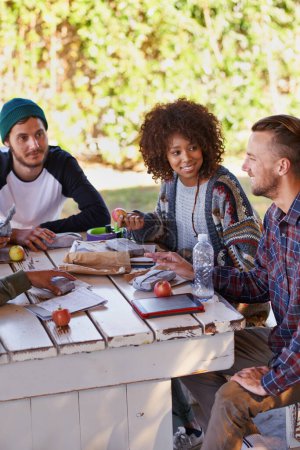 Photo for Study, table and group of university friends with food, conversation or social support in education. Books, tablet and happy students relax together on patio with diversity, lunch and college. - Royalty Free Image