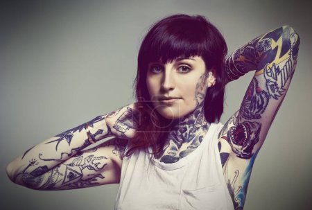 Photo for Portrait, tattoo or edgy woman in tank top on grey background for gothic style isolated in studio. Rockstar, unique or female punk model with ink on skin for body art, fashion or creative expression. - Royalty Free Image