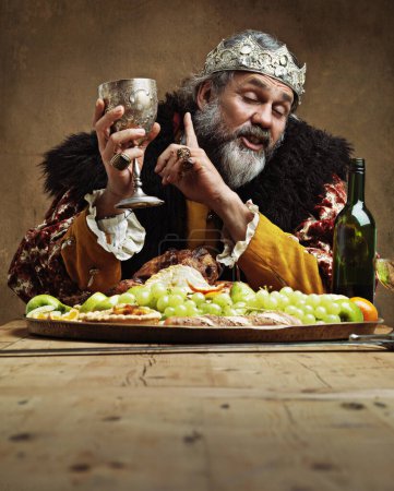 Téléchargez les photos : Roi, festin et boisson dans la table avec verre de vin pour le dîner dans la salle à manger pour la tradition, la culture et le repas dans le palais. Monarque, chef et buffet ou souper lors d'une fête royale en tant que seigneur avec couronne - en image libre de droit