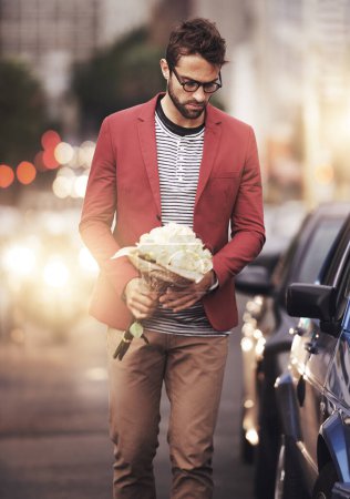 City, man and bouquet of flowers with thinking for romantic gesture, love or gift in New York. Male person, downtown and bunch of roses with idea for kindness, planning or present on valentines day.