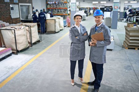 Photo for Manager, smile and portrait in factory for production process, industry and manufacturing for distribution. Workers in uniform together in packaging plant for printing and stock in bag for supplier. - Royalty Free Image