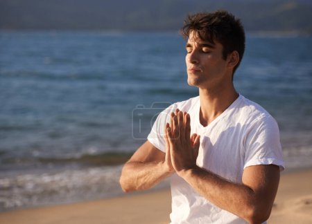 Téléchargez les photos : Méditer, les mains avec la prière et l'homme sur la plage, pleine conscience et zen avec de l'air frais pour le calme extérieur. Océan, bord de mer et Voyage avec yoga pour la santé, la tranquillité d'esprit et la guérison holistique pour l'aura. - en image libre de droit
