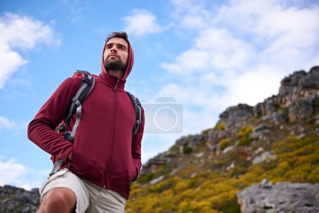 Téléchargez les photos : Man, hiking and mountain with bag in nature, Germany trail for conservation. Active, male person on adventure for health and wellness, confident explorer on backpacking for outdoor sport or walk. - en image libre de droit