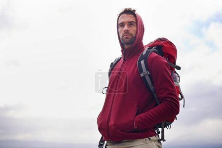 Photo for Sky, thinking and man with backpack, camping or hiking in nature for adventure and peace. Contemplation, vacation and male person in trip, thoughtful and journey for holiday and outdoor for relax. - Royalty Free Image