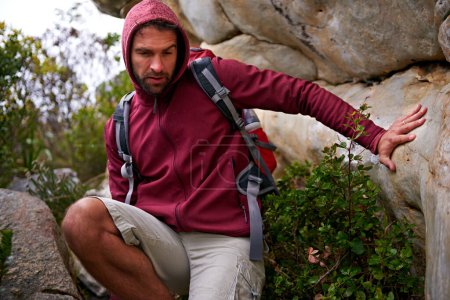 Photo for Cave, rock climbing and man hiking in mountain with backpack for adventure for wellness in trip. Earth, fitness and male person in environment to relax, peace and gear on hill or cliff and land. - Royalty Free Image