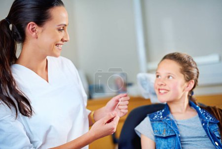 Photo for Woman, dentist and child with floss, girl and smile in a modern office and wellness with care. Trust, support and oral health with string or patient with dental hygiene and cheerful with professional. - Royalty Free Image