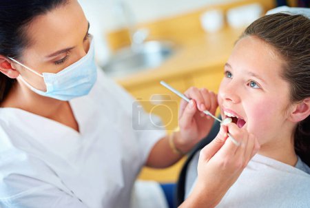 Photo for Woman, dentist and child for teeth consultation or appointment for dental cavity, whitening or examination. Female person, face mask and oral hygiene with tools for gum diagnosis, equipment or tooth. - Royalty Free Image