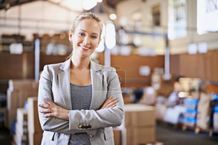 Photo for Woman, smile and crossed arms for portrait in warehouse for logistics, shipping or distribution. Business person, happy and confident in factory with production for supply chain industry in Liverpool. - Royalty Free Image