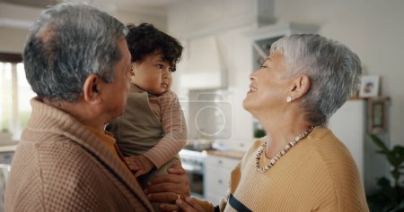 Téléchargez les photos : Sourire, amour et grands-parents avec petit-enfant à la maison pour coller dans le salon ensemble. Heureux, famille et femme âgée et homme du Mexique avec un bébé, un tout-petit ou un enfant à la maison moderne - en image libre de droit