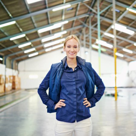 Photo for Woman, confidence and smile in factory in portrait for logistics, shipping and freight with cargo for manufacturer with industrial shipment. Female person, pride and plant with supply chain system. - Royalty Free Image
