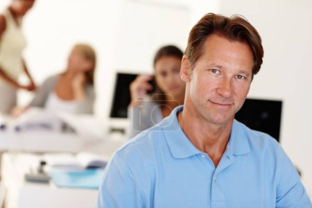 Mature, man and closeup in office with smile for work, business consultant or advisor with colleagues. Male person, workplace and job with team and happy for experience, professional or specialist.