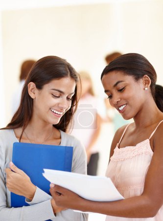 Photo for College, students and papers for discussion for education, assignment or research project with smile. Diversity, friends and conversation with study materials for group work or test in university. - Royalty Free Image