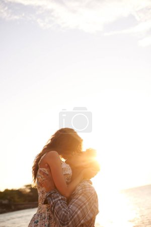 Foto de Pareja, besa en la playa y viaja con puesta de sol, océano y vacaciones en Cancún por fecha o aniversario por amor. Afecto, unión y abrazo con las personas en aventura juntos, compromiso y confianza al aire libre. - Imagen libre de derechos