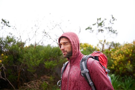 Photo for Extreme, hiking and man in rain, walking and holiday for survival adventure, outdoor and trekking. Water, traveller and male person with backpack in tough environment, rough and destination of Europe. - Royalty Free Image