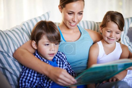 Photo for Mother, children and reading on sofa with book for fantasy story and learning for english literature or language skills for development. Family, relax and happy on couch in home with love and bonding. - Royalty Free Image