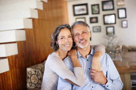 Photo for Love, hug and portrait of mature couple in a house with support, safety and security, care or bonding. Happy, marriage or face of people embrace in living room with solidarity, trust or holding hands. - Royalty Free Image