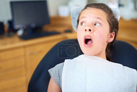 Photo for Dental, wow or scared girl in consultation room with phobia, worry or fear for dentist exam. Orthodontics, stress or teen person nervous for teeth, cavity or bacteria, risk or gum disease emergency. - Royalty Free Image