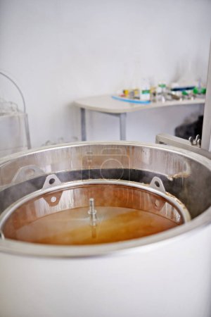 Brewery, tank or craft beer in machine for production with manufacturing process, wort and alcohol in a keg. Industrial industry, closeup and brewing equipment in factory, warehouse or small business.