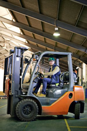Photo for Man, forklift and driving in warehouse for site inspection, management and supply chain industry. Male employee, hardhat and operating machinery for factory check up, freight export and services - Royalty Free Image