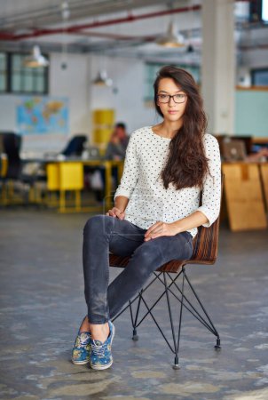 Photo for Business, woman and serious with portrait in chair for creative internship, confidence, startup pride and glasses. Entrepreneur, employee and relax in a warehouse workspace and coworking environment. - Royalty Free Image
