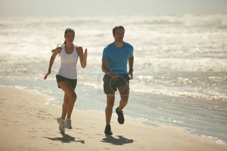 Photo for Couple, fitness and running on beach with exercise, workout or outdoor training together in nature. Man and woman enjoying walk or run for physical activity or cardio on the ocean coast with partner. - Royalty Free Image
