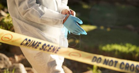 Photo for Forensic, gloves and police tape at crime scene for investigation, getting ready and hazmat for protection. Csi quarantine, expert investigator and outdoor for observation, evidence and case research. - Royalty Free Image