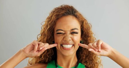 Photo for Woman, funny face and studio with goofy comedy on grey background or humor mockup space, silly or joking. Female person, model and comic emoji expression with tongue out, peace sign or hand gesture. - Royalty Free Image