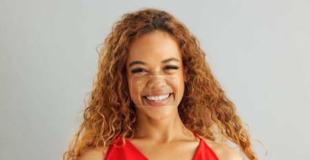 Photo for Happy woman person, wink and laughing in studio, excited and flirt on grey background. Cheerful, joyful and smile on female model face, friendly and natural with curly hair of fun African Lady. - Royalty Free Image