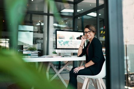 Photo for Anything is possible if youre prepared to work for it. Cropped portrait of an attractive young businesswoman sitting alone at her desk in her office - Royalty Free Image