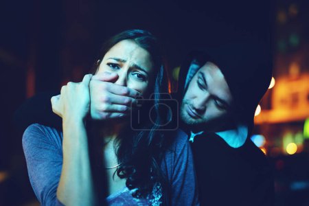 Photo for Woman, criminal and hand on mouth with terror for violence, danger and robbery in city at night with bokeh. People, portrait and silence emoji with fear, crime and gangster for kidnapping and hostage. - Royalty Free Image