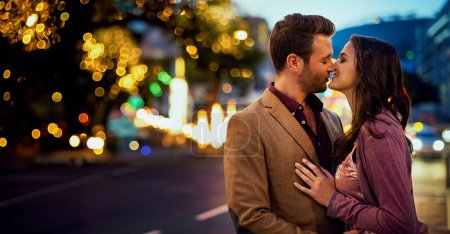 Téléchargez les photos : Couple, nuit et baiser en ville pour l'amour, toucher le nez et coller pour le romantisme et le moment doux. Affection, personnes heureuses dans l'engagement et la confiance, la sécurité et le soutien ainsi que le temps extérieur. - en image libre de droit