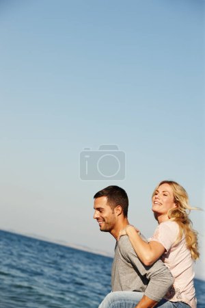 Photo for Couple, carry and piggyback on vacation, ocean and peace at beach or game by blue sky. People, mockup space and tropical island for bonding on weekend, outdoor nature and love for marriage or romance. - Royalty Free Image