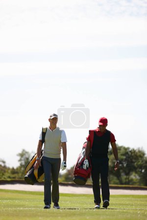 Photo for Smile, friends and men walking on golf course with golfing bag for training, health and teamwork. Male people, sports equipment and exercise for activity with sportswear, lawn and trees outdoor. - Royalty Free Image
