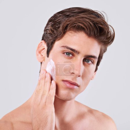 Photo for Man, portrait and skincare with facial cream, lotion or grooming for hygiene on white studio background. Closeup, male person or young model with face creme, sunscreen or moisturizer on mockup space. - Royalty Free Image