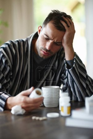 Photo for Sick, man and reading vitamin medicine at home holding mug with herbal tea for recovery. Happy, male and pills for illness, disease and virus smiling for good news on positive health results. - Royalty Free Image