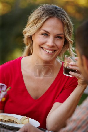 Photo for Woman, happy or smiling with cup on picnic date with partner for love, romance and memories together. Person, drinking and eating healthy meal with boyfriend for conversation, bonding or relationship. - Royalty Free Image