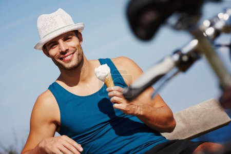 Photo for Man, ice cream and portrait with bike for relax outdoor, travel and break for recreation on summer holiday. Young person, smile and sitting with dessert cone for weekend fun and gelato sorbet outside. - Royalty Free Image