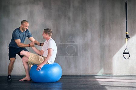 Photo for Amputee, exercise ball and rehabilitation with physiotherapist at gym for training with motivation. Fitness, professional and patient with disability for wellbeing with workout, health and happy. - Royalty Free Image