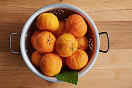 Photo for Home, healthy or bowl of tangerines in kitchen for wellness, organic or balanced diet for nutrition, meal or fiber. Background, above and bunch of natural ingredients with vitamin c or orange fruits. - Royalty Free Image