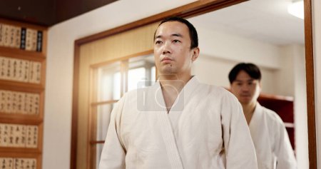 Photo for Aikido student, ready or men in dojo to start practice, discipline or self defense education in Japan. Master, people learning sports or athletes walking in fighting class, lesson or training. - Royalty Free Image