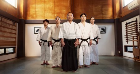Photo for Aikido class, group and portrait for martial arts, sensei or ready for training, gym or contest in dojo. Japanese people, sport or exercise in club, workout or fitness for fight, black belt or battle. - Royalty Free Image