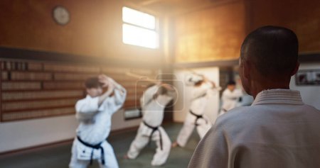 Téléchargez les photos : Aïkido, dojo et classe avec sensei, entraînement d'armes et épée en bois pour l'exercice d'autodéfense. Groupe, étudiant ou athlète dans un studio japonais gymnase avec défi de combat, pratique de la ceinture noire et fitness. - en image libre de droit