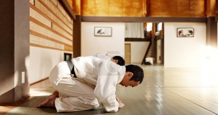Foto de Estudiante japonés, arco o hombres en dojo para iniciar la práctica de aikido, disciplina o educación de autodefensa. cinturón negro maestro saludo, personas aprendiendo respeto o sensei listo en la lucha contra la clase o la formación. - Imagen libre de derechos