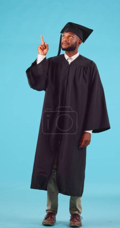Photo for College student, pointing and graduation space in studio for future scholarship. Portrait, advertising and unsure black male show marketing for university choice, doubt or decision on blue background. - Royalty Free Image