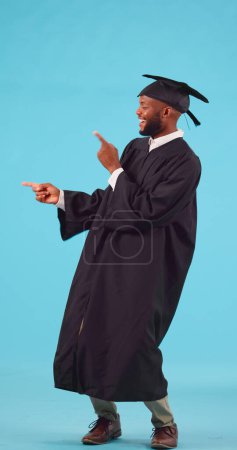 Foto de Marketing, graduación y estudiante masculino en un estudio que muestra una promoción o publicidad. Feliz, sonrisa y joven africano graduado con un gesto de la mano presentación aislado por un fondo azul - Imagen libre de derechos