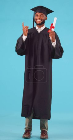 Photo for Marketing, pointing and male graduate with a diploma in studio for achievement, success or goal. Graduation, advertising and portrait of African man university student with degree by blue background - Royalty Free Image