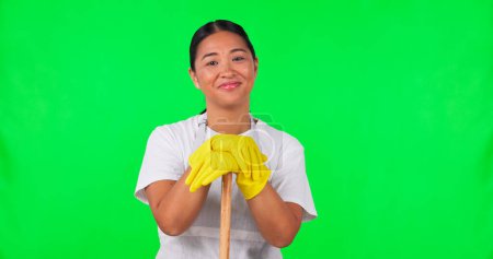 Photo for Woman, cleaner and face, green screen and broom with household maintenance and cleaning service. Disinfection, janitor and hygiene with female person and in gloves, mockup space on studio background. - Royalty Free Image