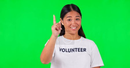Photo for Volunteer, green screen and a woman pointing at space for advertising, charity or information. Face of happy asian person with a hand and tshirt for nonprofit project, NGO help or donation in studio. - Royalty Free Image